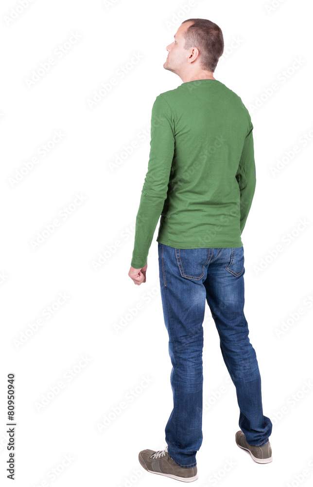Back view of young man in t-shirt and jeans looking. Back view of young man in t-shirt and jeans looking.