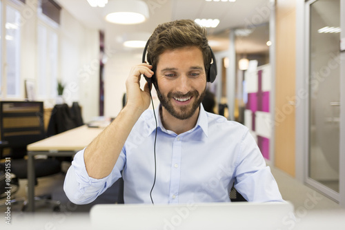 Smiling Businessman in the office on video conference, headset,