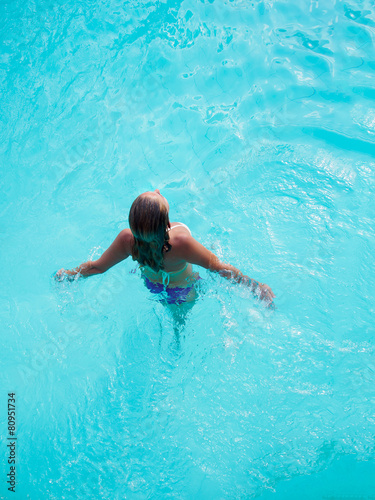 A girl is relaxing in a swimming pool