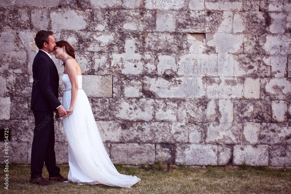 Bride and groom kissing near brick wall Bride and groom kissing near brick wall