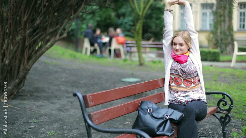 Pretty girl sitting on the bench and relaxing 
