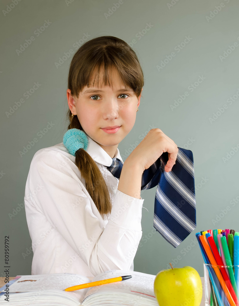 schoolgirl sits at a school desk Stock Photo | Adobe Stock