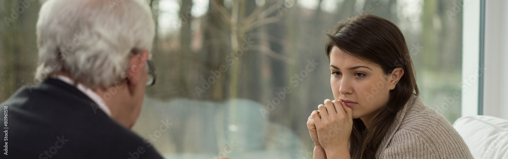 Sad teenager talking with psychologist