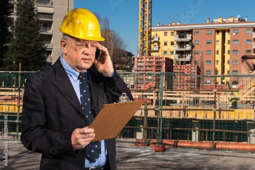 Ingegnere  che controlla i lavori nel cantiere photo