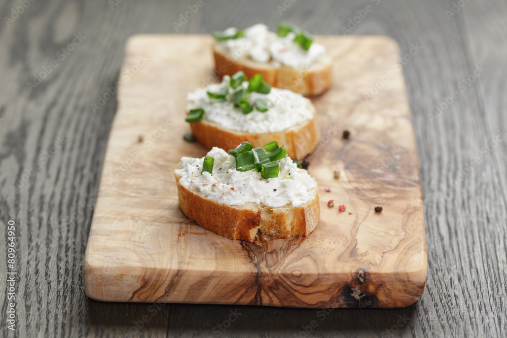 crunchy baguette slices with cream cheese and green onion on crunchy baguette slices with cream cheese and green onion on