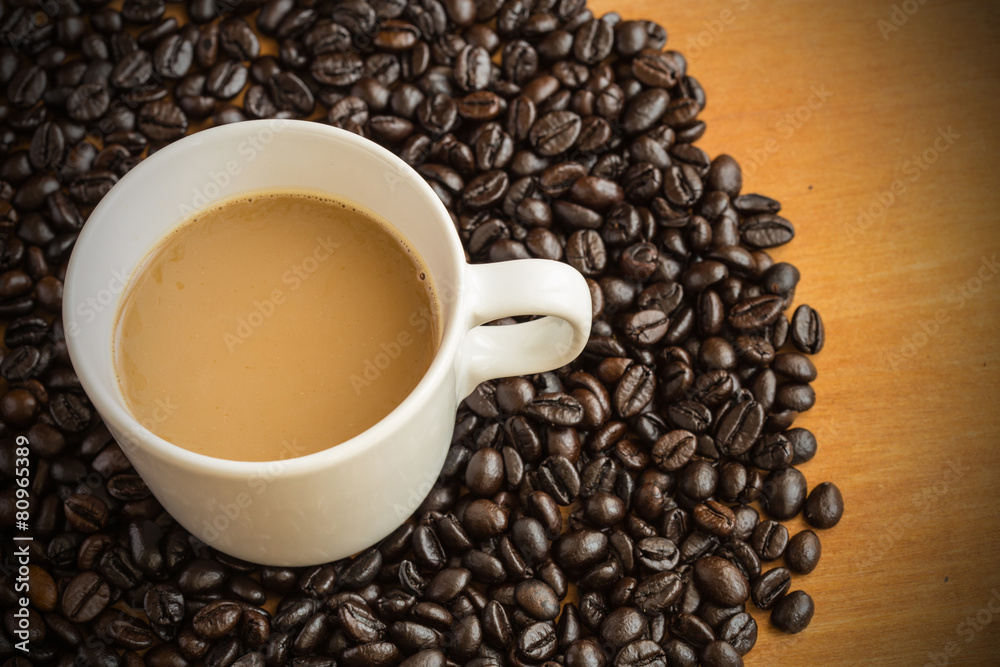 Fototapeta premium Hot latte coffee cup on coffee beans background.