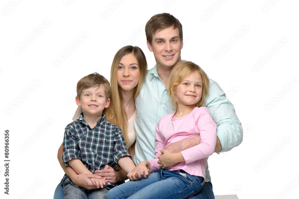 Cheerful young family of four posing