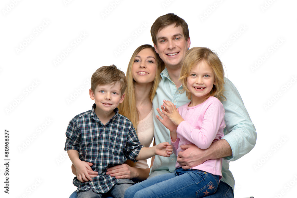Smiling young family of four posing