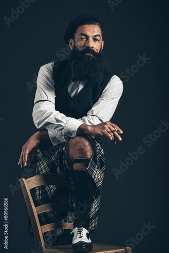 Scotsman in a kilt smoking a cigarette