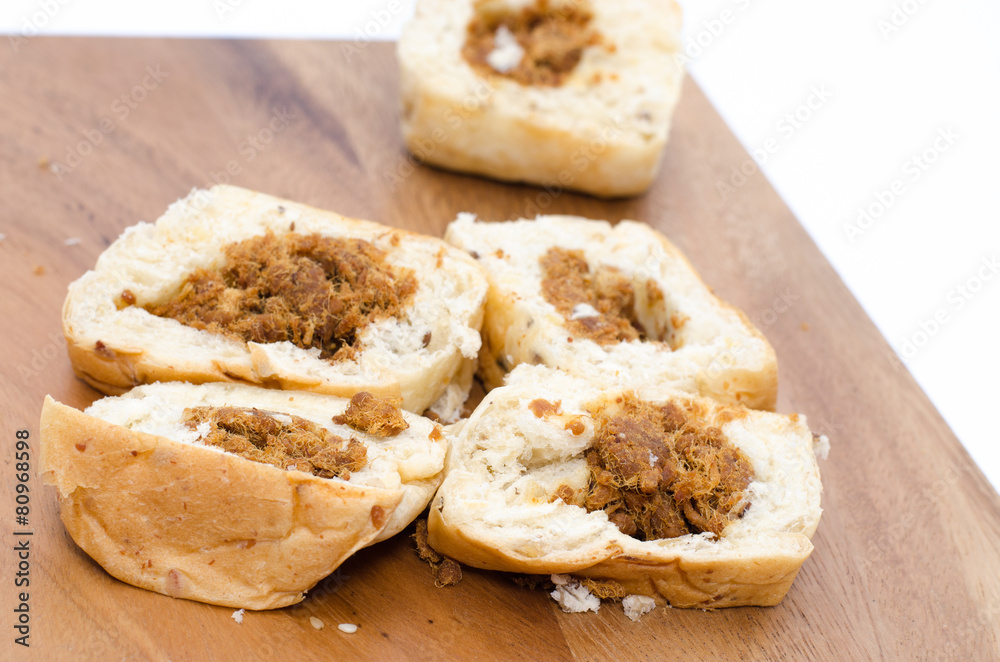 Bread slices on wood cutting board on white background