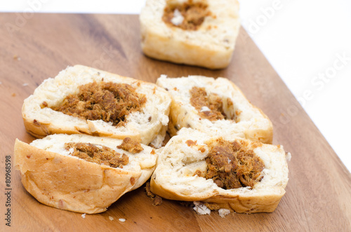 Bread slices on wood cutting board on white background