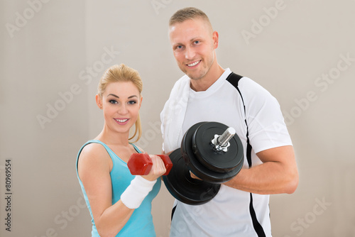 Young Couple Exercising With Dumbbells