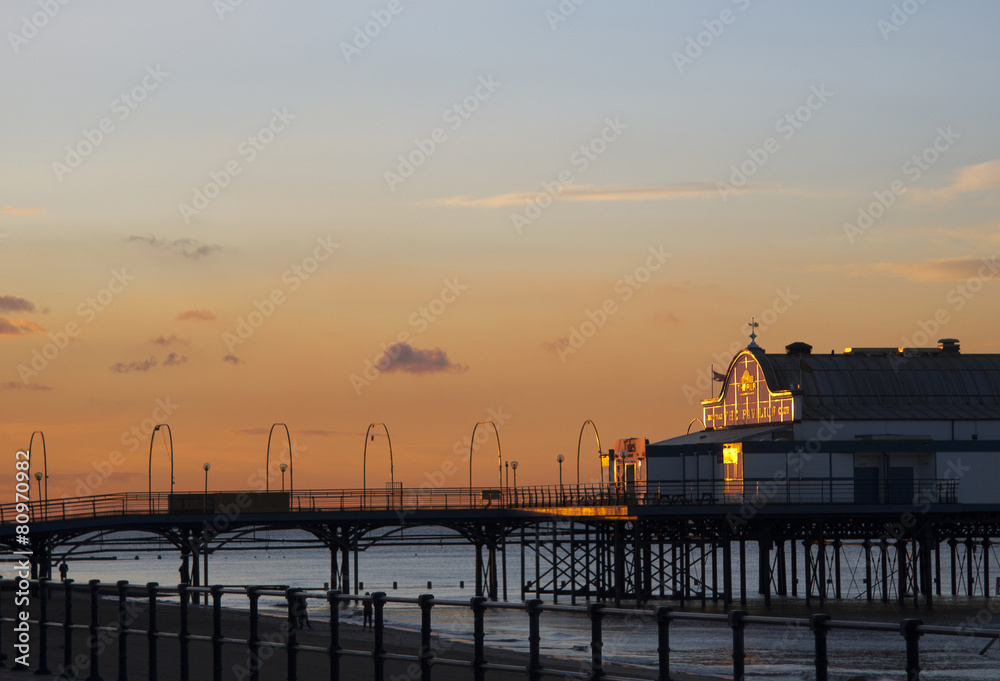 Seaside pier in Cleethorpes at sunset, orange sky reflecting on the front of the building Seaside pier in Cleethorpes at sunset, orange sky reflecting on the front of the building