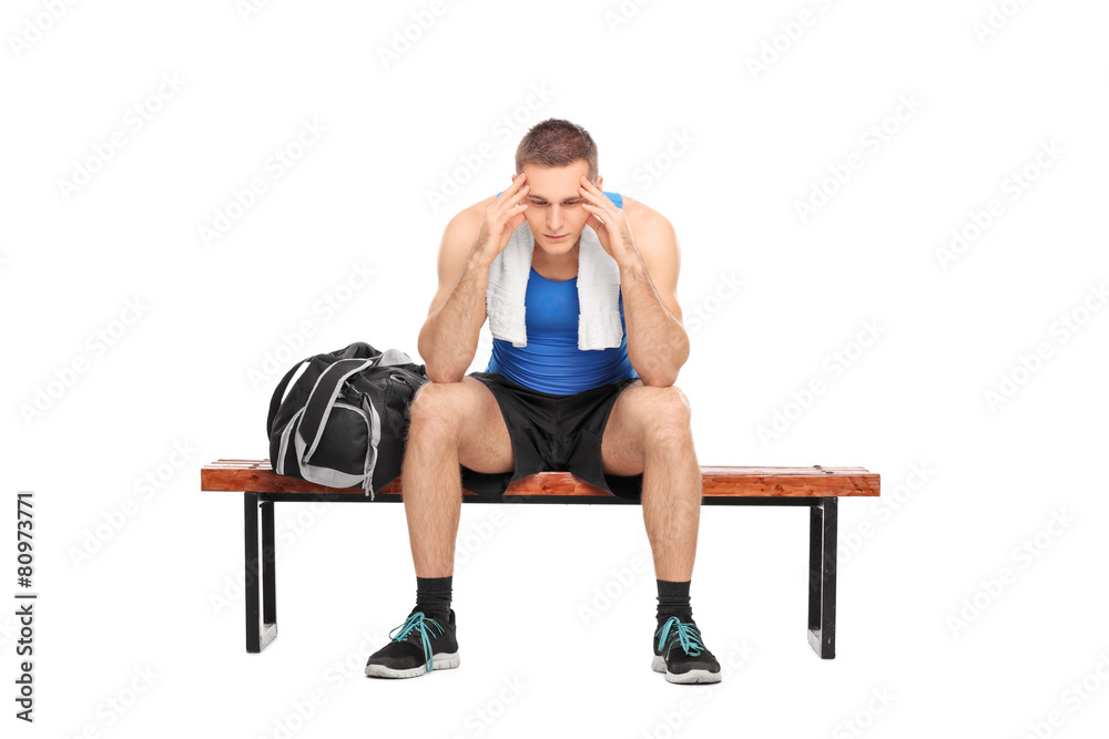 Worried athlete sitting on a bench