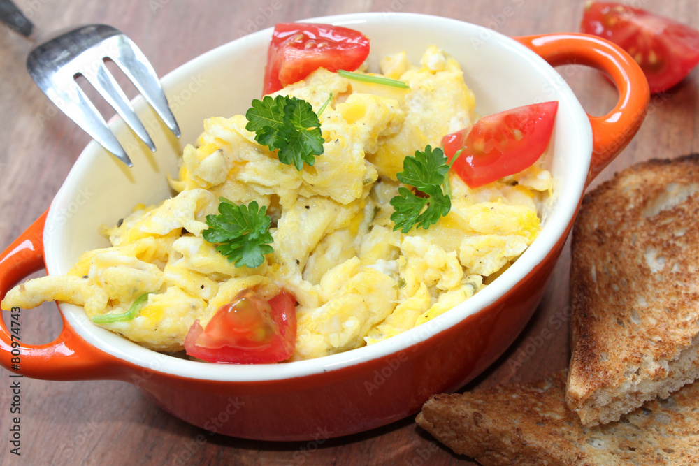 Rührei mit Tomaten und Toast zum Frühstück Rührei mit Tomaten und Toast zum Frühstück