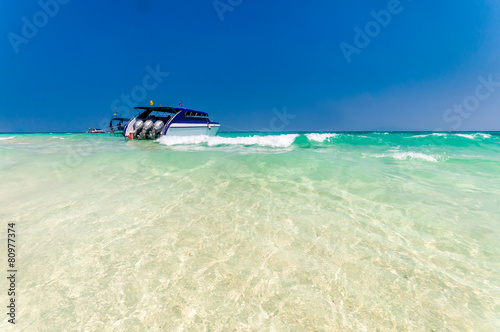 Boat docking in front of the white sand beach © normalfx