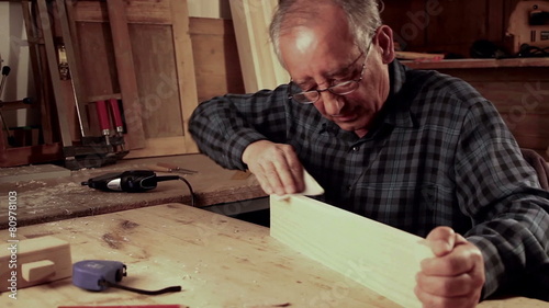 Senior carpenter carving wood with engraver tool. photo