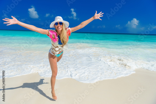 long haired blonde woman with flower in hair in bikini on