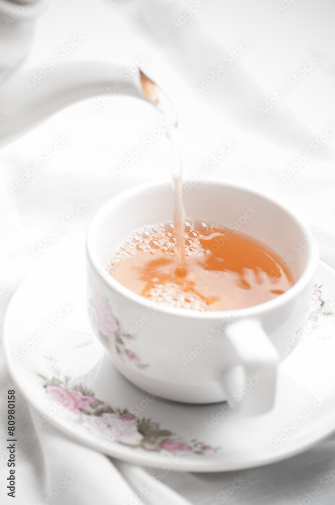 Tea being poured into tea cup Tea being poured into tea cup