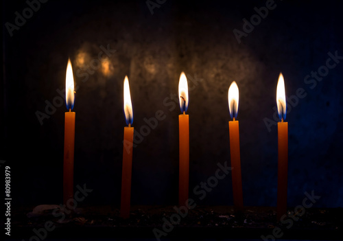 Burning candles on wooden with black background