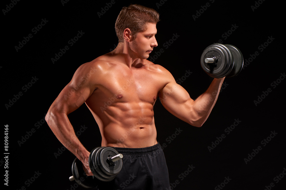 Shirtless young powerful muscular sportsman pumping biceps