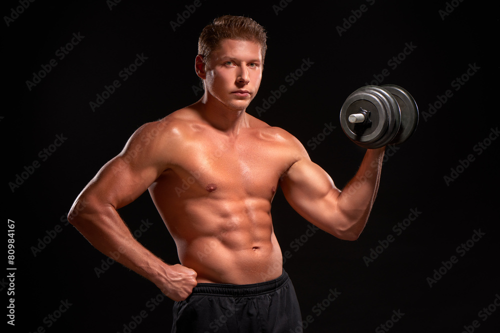 Shirtless young powerful muscular sportsman pumping biceps