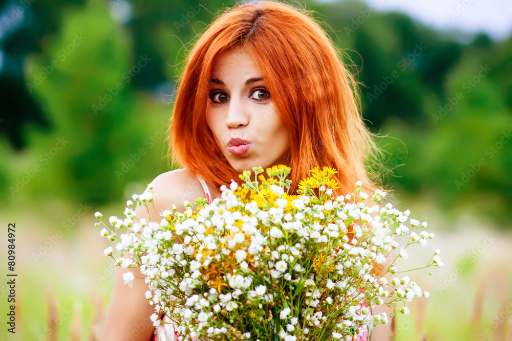 portrait of a young red-haired girl with wild flowers