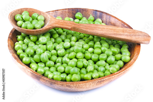 Green peas in a wooden plate.