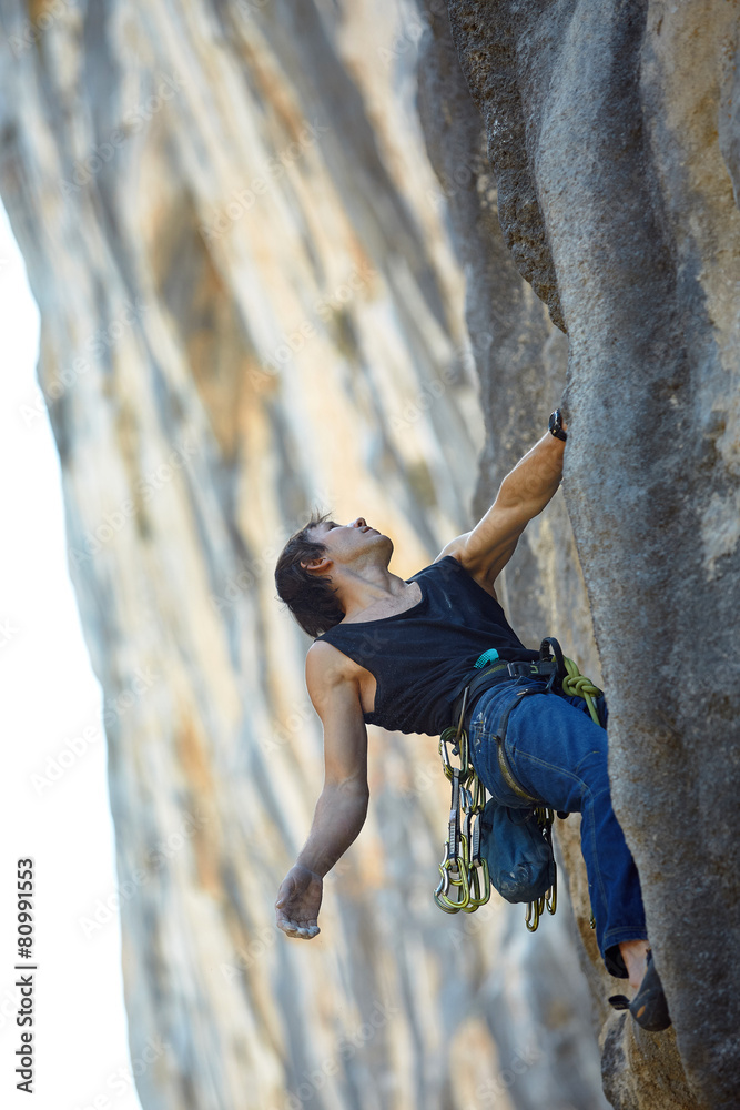 Rock climber climbing up a cliff