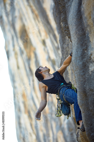 Fototapeta Naklejka Na Ścianę i Meble -  Rock climber climbing up a cliff