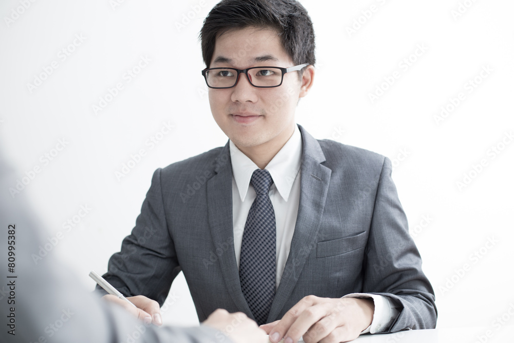 Two businessmen looking at report and having a discussion in off Two businessmen looking at report and having a discussion in off
