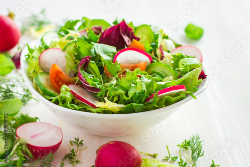 Healthy salad with fresh vegetables and ingredients on white bac