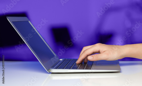 Businessman pressing modern laptop computer on colorful backgrou