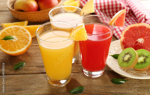 Fresh juices with fruits on wooden table