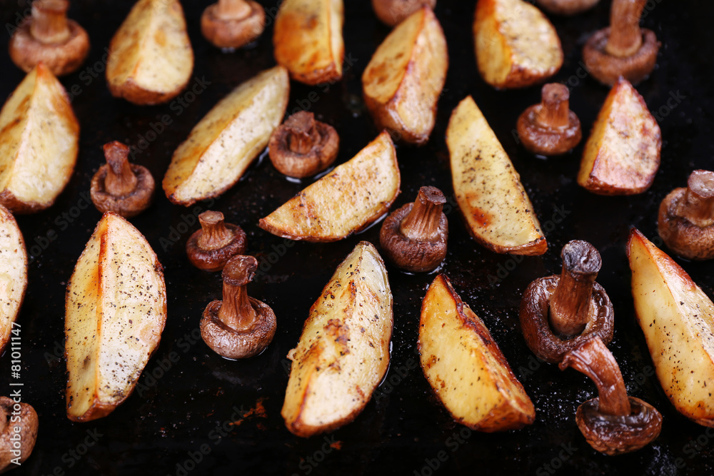 Baked potatoes with mushrooms and spices on pan close up Baked potatoes with mushrooms and spices on pan close up