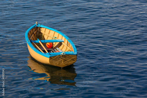 Tableau sur toile A small row boat sitting calmly in a harbor