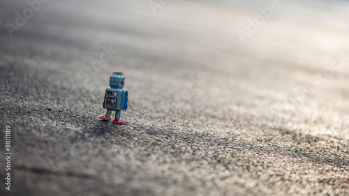Little retro tin robot walking down road