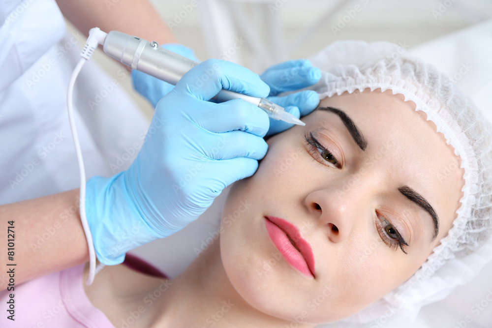 Cosmetologist applying permanent make up on eyes, close-up Cosmetologist applying permanent make up on eyes, close-up