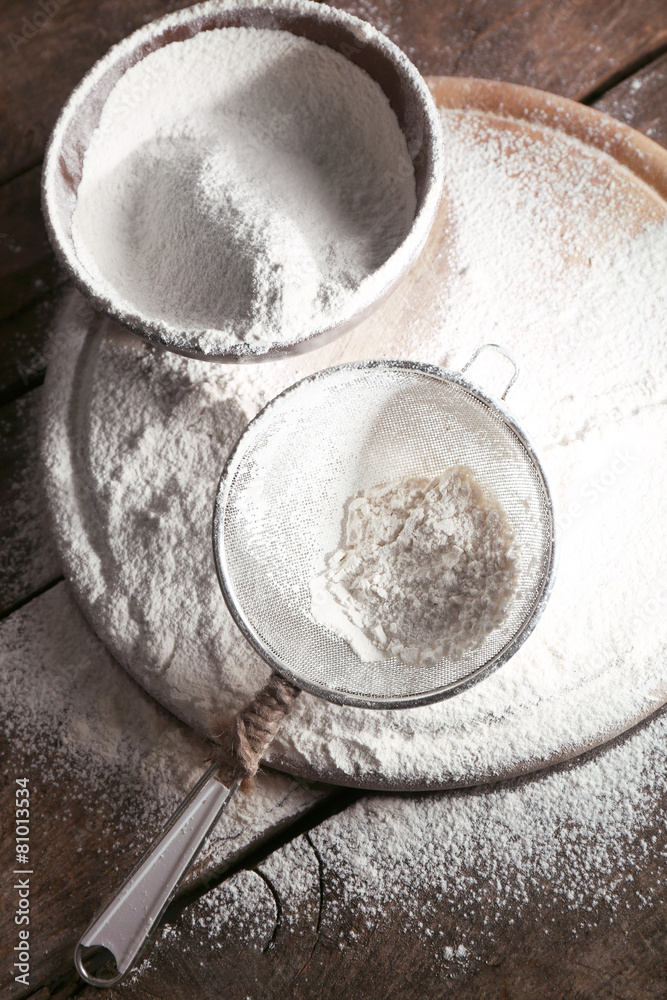 White flour on cutting board on wooden table background White flour on cutting board on wooden table background
