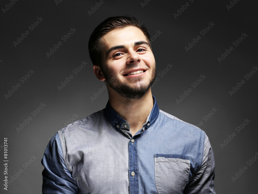 Obraz premium Portrait of young man in blue shirt on gray background