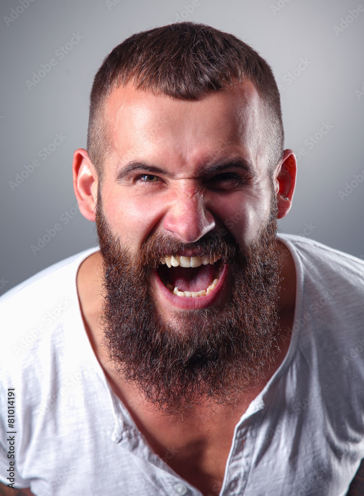 Portrait of handsome bearded man standing, isolated on grey Portrait of handsome bearded man standing, isolated on grey