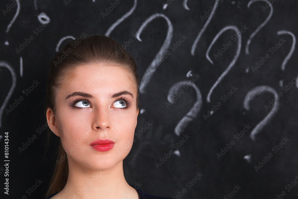 Young girl with question mark on a gray background Young girl with question mark on a gray background