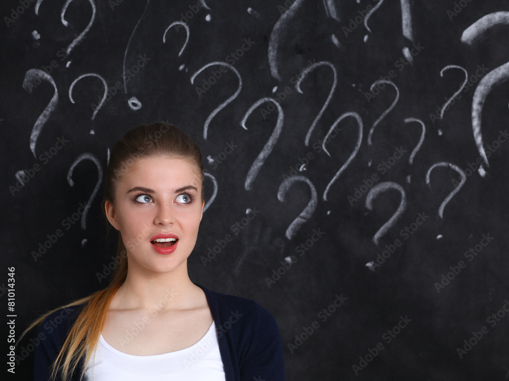Young girl with question mark on a gray background Young girl with question mark on a gray background