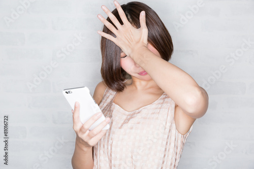 スマホを見て落ち込む女性 Stock Photo Adobe Stock