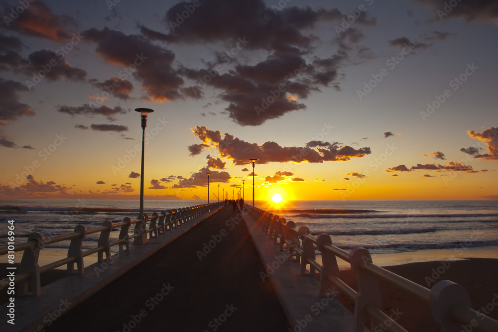 Forte dei marmi's pier at sunset with some people walking