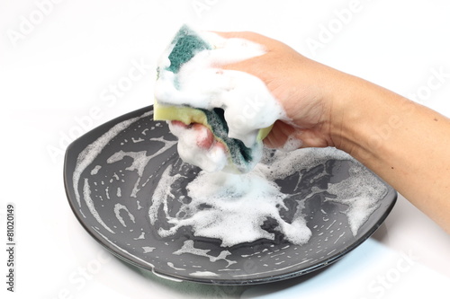 washing dishes with a sponge and dishwashing liquid