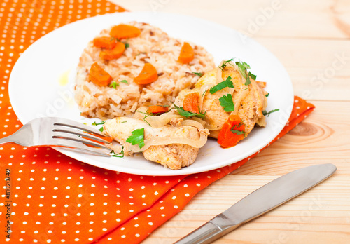 fried chicken with rice in white plate on wooden table