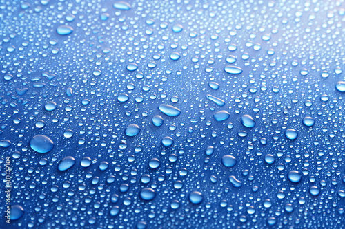 Water drops on glass on blue background