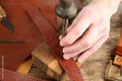 Repairing leather belt in workshop