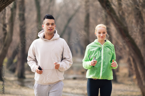 Young couple jogging and listening to music